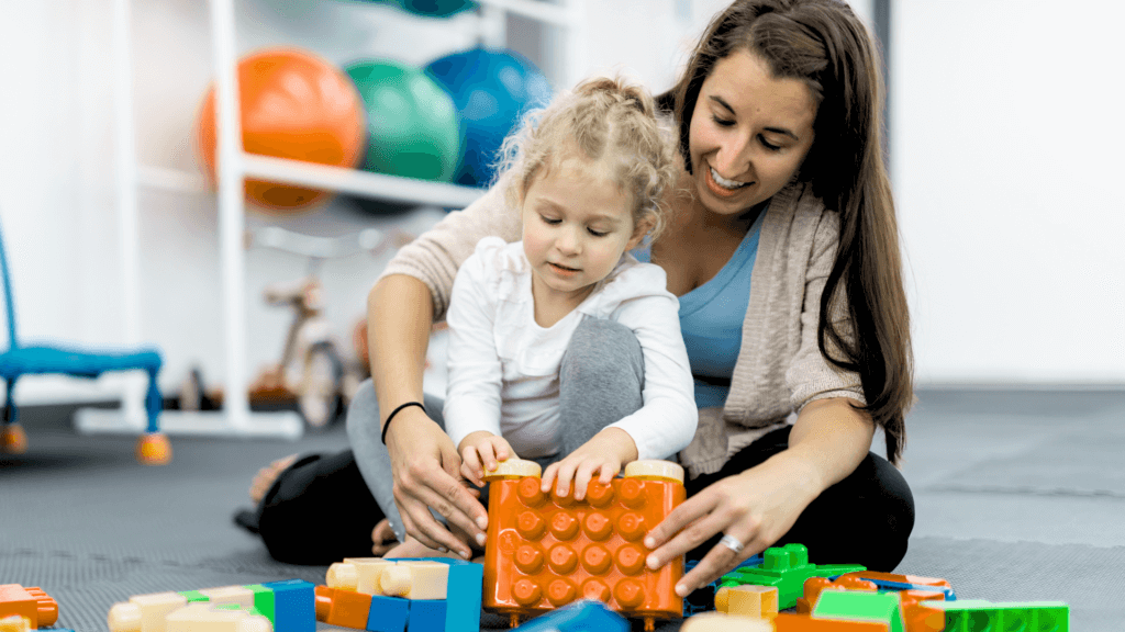 a woman provides occupational therapy to an autistic child at a therapy center